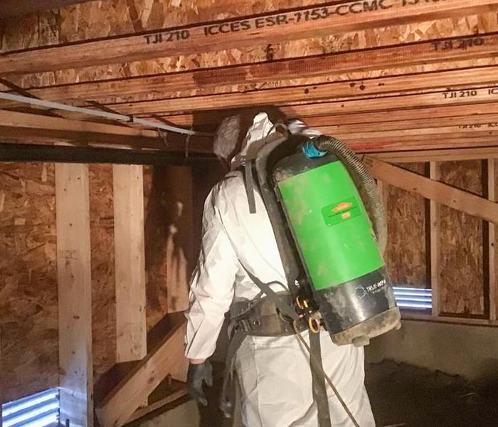 servpro employee in ppe cleaning a crawlspace