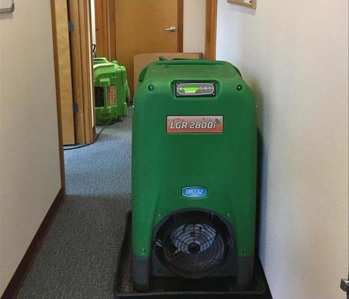 Dehumidifier and air mover placed on the floor of a commercial building